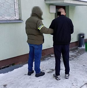 policjant prowadzi zatrzymanego