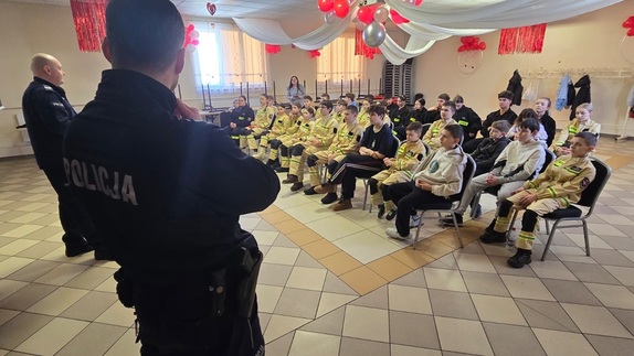 policjanci stoją przed uczestnikami spotkania