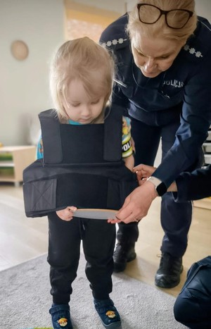 policjantka pokazuje dziecku znak drogowy