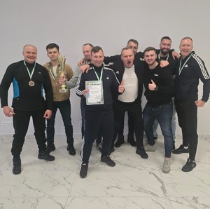 drużyna bialskiej policji. Funkcjonariusze stoją z dyplomem i pucharem