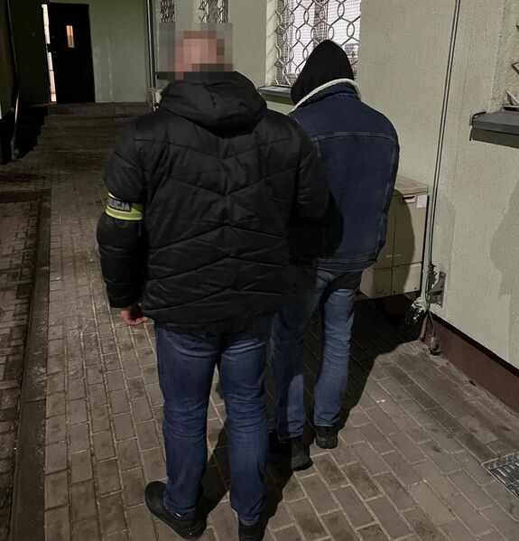 policjant prowadzi zatrzymanego