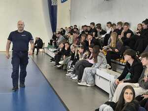 Funkcjonariusz Policji na sali gimnastycznej z uczniami