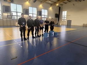 Funkcjonariusz Policji z uczniami i wojskiem na szkolnej sali gimnastycznej