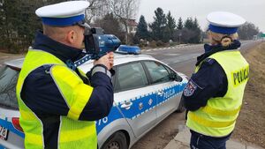 policjanci wydziału ruchu drogowego. Policjant stoi z laserowym miernikiem predkości