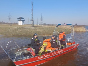 policjantki i strażacy na łodzi