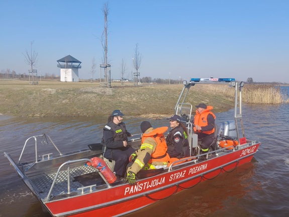 policjantki i strażacy na łodzi