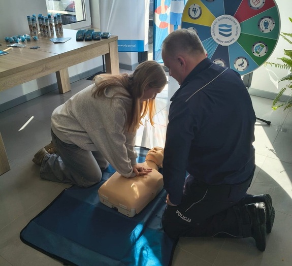 policjant i osoba ćwicząca na fantomie masaż serca