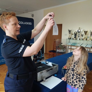 policjantka pokazuje odbitkę linii papilarnych