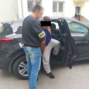 policjant wprowadza zatrzymanego