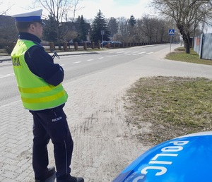 policjant przy radiowozie obserwuje rejon przejścia dla pieszych