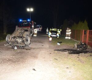 samochód leży na dachu. Obok funkcjonariusze wykonują czynności.