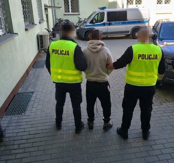 Policjanci prowadzą zatrzymanego mężczyznę