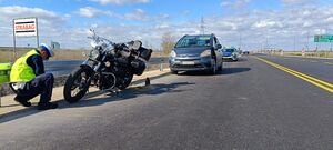 policjant umundurowany kucający przed motocyklem