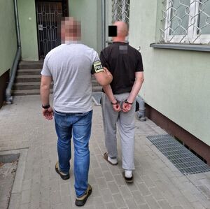 policjant prowadzi zatrzymanego