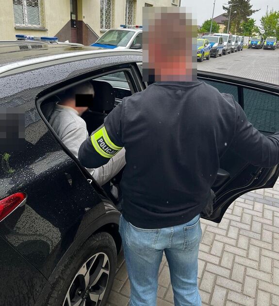 policjant prowadzi zatrzymanego mężczyznę