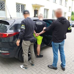 policjanci wprowadzają mężczyznę do radiowozu