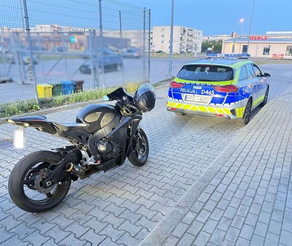 radiowóz oraz stojący za nim motocykl
