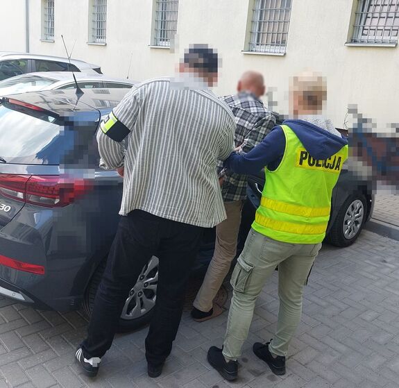 policjanci wprowadzają mężczyznę do samochodu
