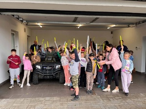 policjant z dziećmi prezentującymi elementy odblaskowe