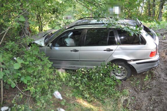 uszkodzony samochód stoi w rowie, poza drogą obok drzewa