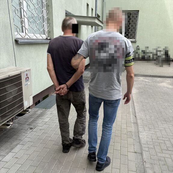policjant prowadzi zatrzymanego meżczyznę