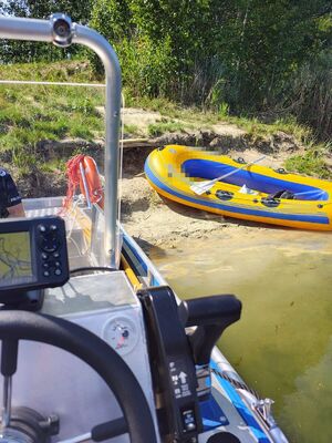 zdjęcie przedstawia policyjną łódź i zacumowany na brzegu ponton