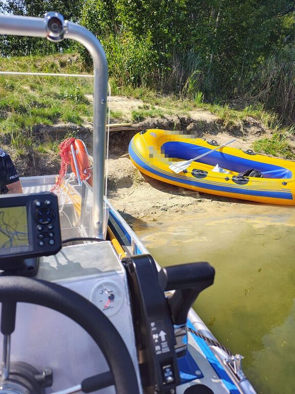 zdjęcie przedstawia policyjną łódź i zacumowany na brzegu ponton