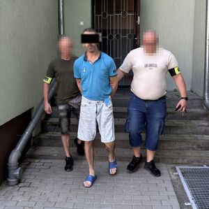 policjanci prowadzą zatrzymanego