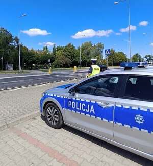 policjant ruchu drogowego stoi przy radiowozie
