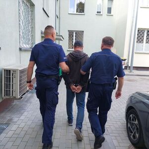 policjanci prowadzą zatrzymanego mężczyznę