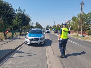 policjant w rejonie szkoły zatrzymuje auto do kontroli drogowej