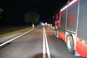 miejsce wypadku drogowego. Po prawej stronie wóz straży pożarnej. W tle inne służby