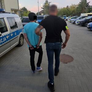 policjant prowadzi zatrzymanego