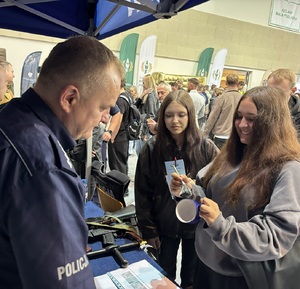 policjant pokazuje uczestnikom sposób zabezpieczania odbitek linii papilarnych