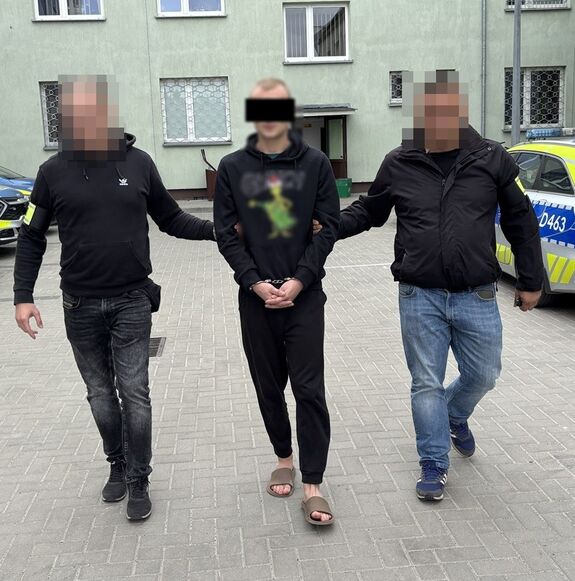 policjanci prowadzą zatrzymanego mężczyznę