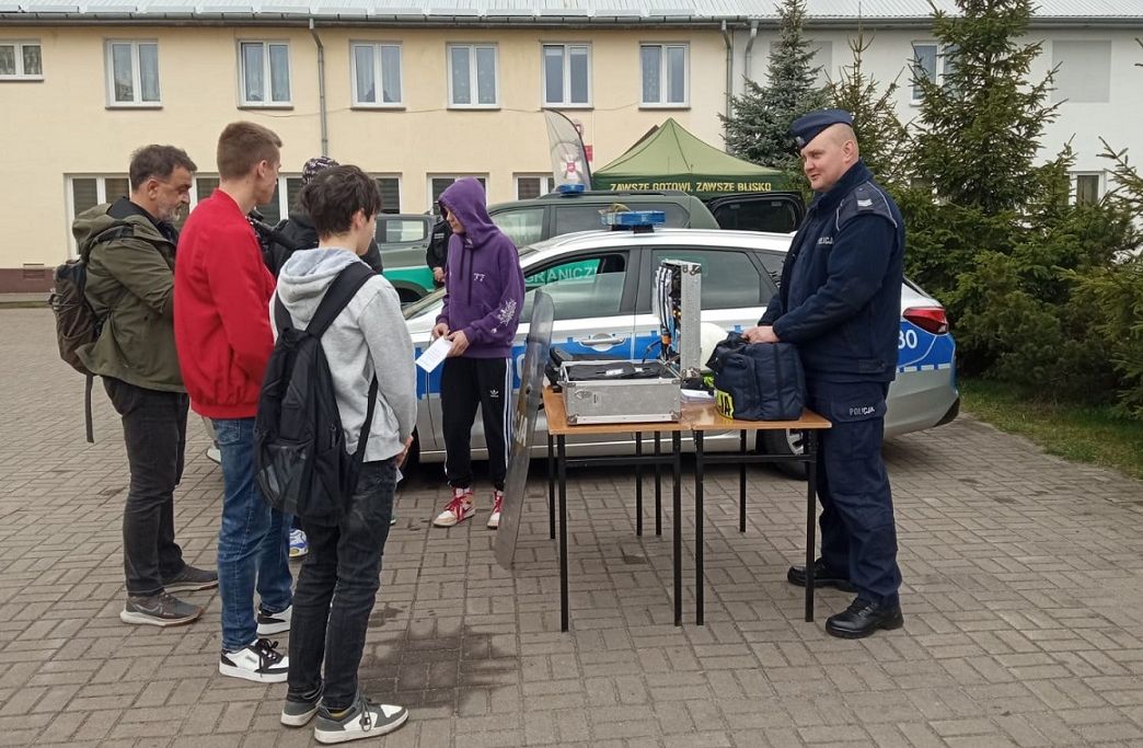 policjant na stoisku. Obok osoby odwiedzające stoisko