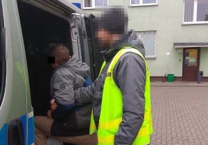 fot. Policjant doprowadza zatrzymanego