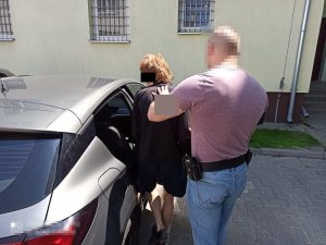Policjant doprowadza zatrzymaną