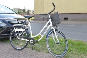 stojący rower oraz fragment samochodu