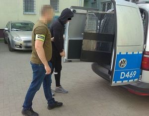 nieumundurowany policjant doprowadza zatrzymanego