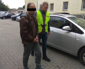 policjant doprowadza zatrzymanego