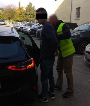 policjant doprowadzający zatrzymanego