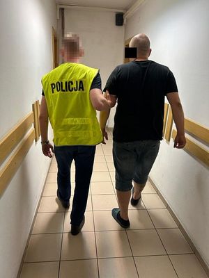 policjant prowadzi zatrzymanego